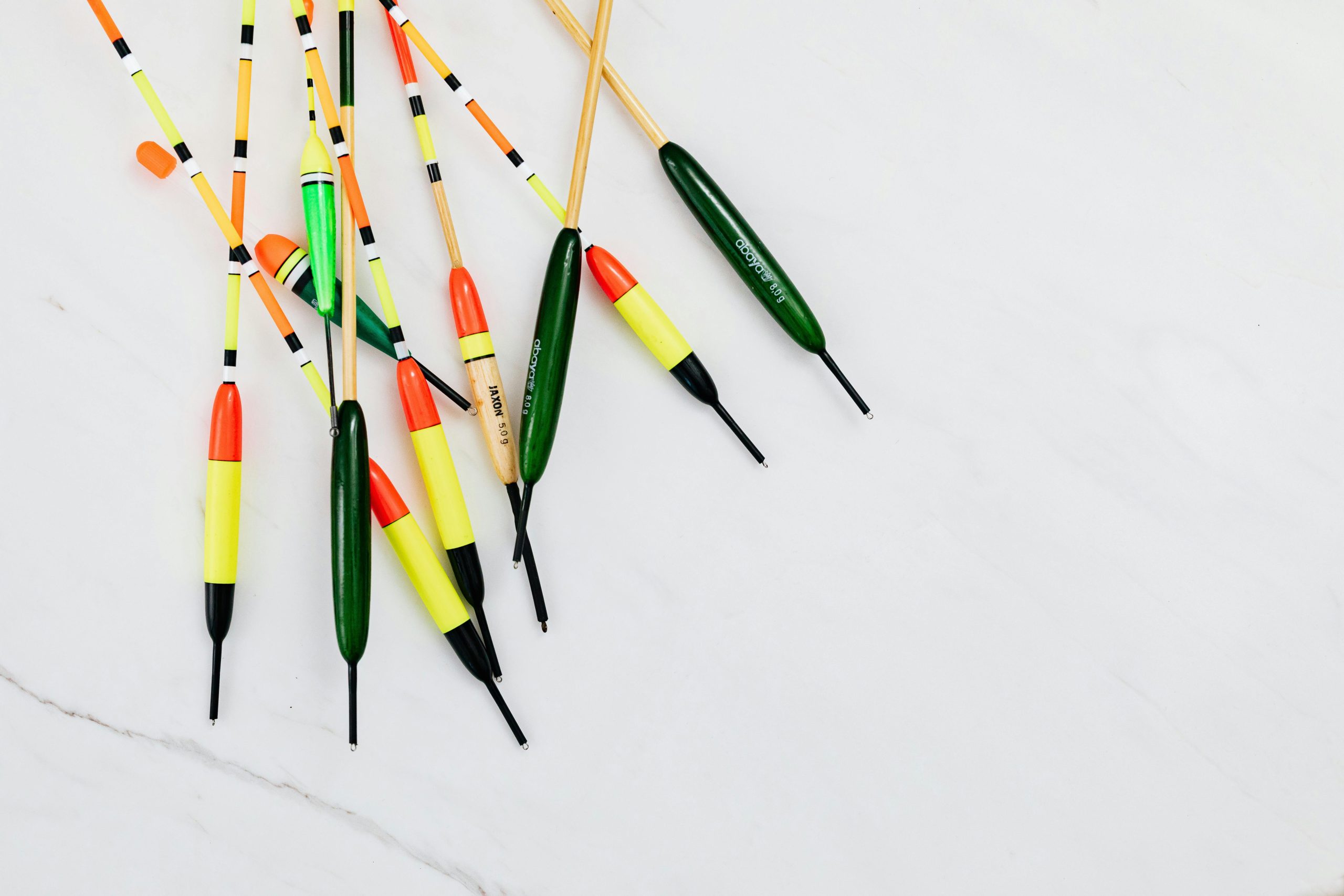 A collection of colorful fishing floats displayed on a white marble surface.